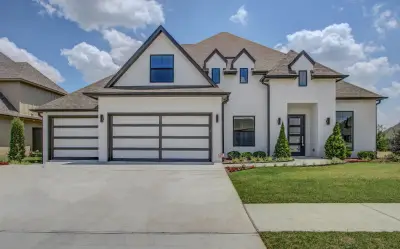 A large white house with two garage doors.