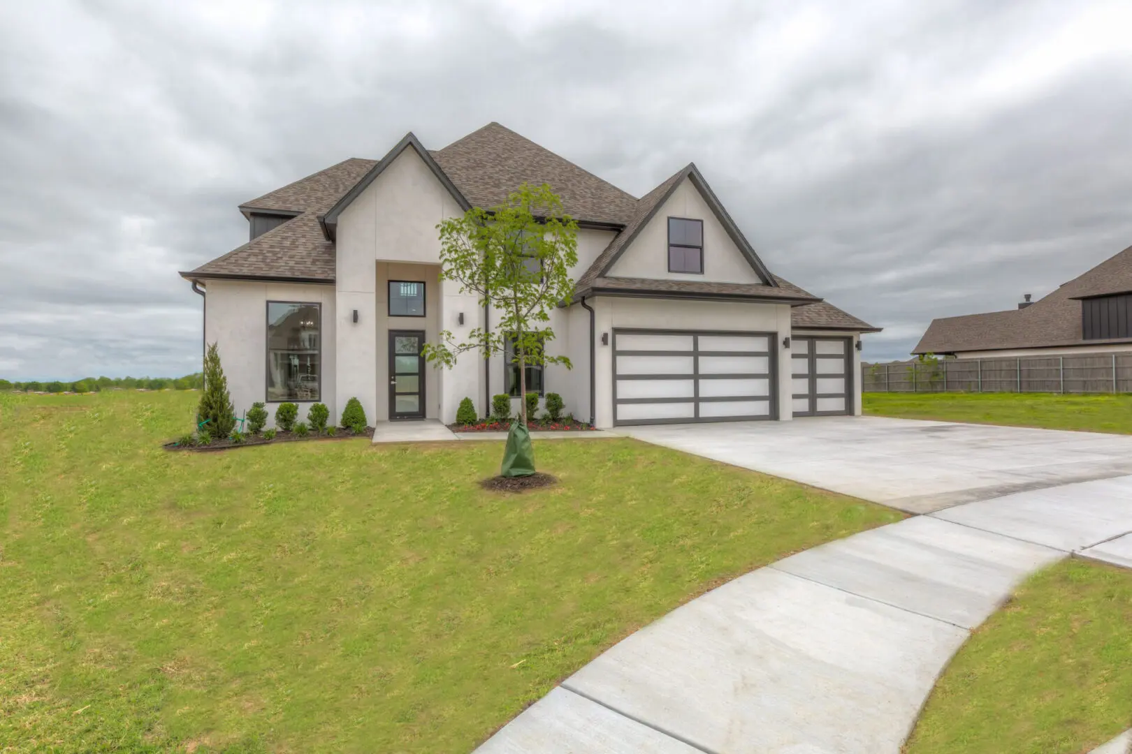 A large white house with a driveway in front of it.