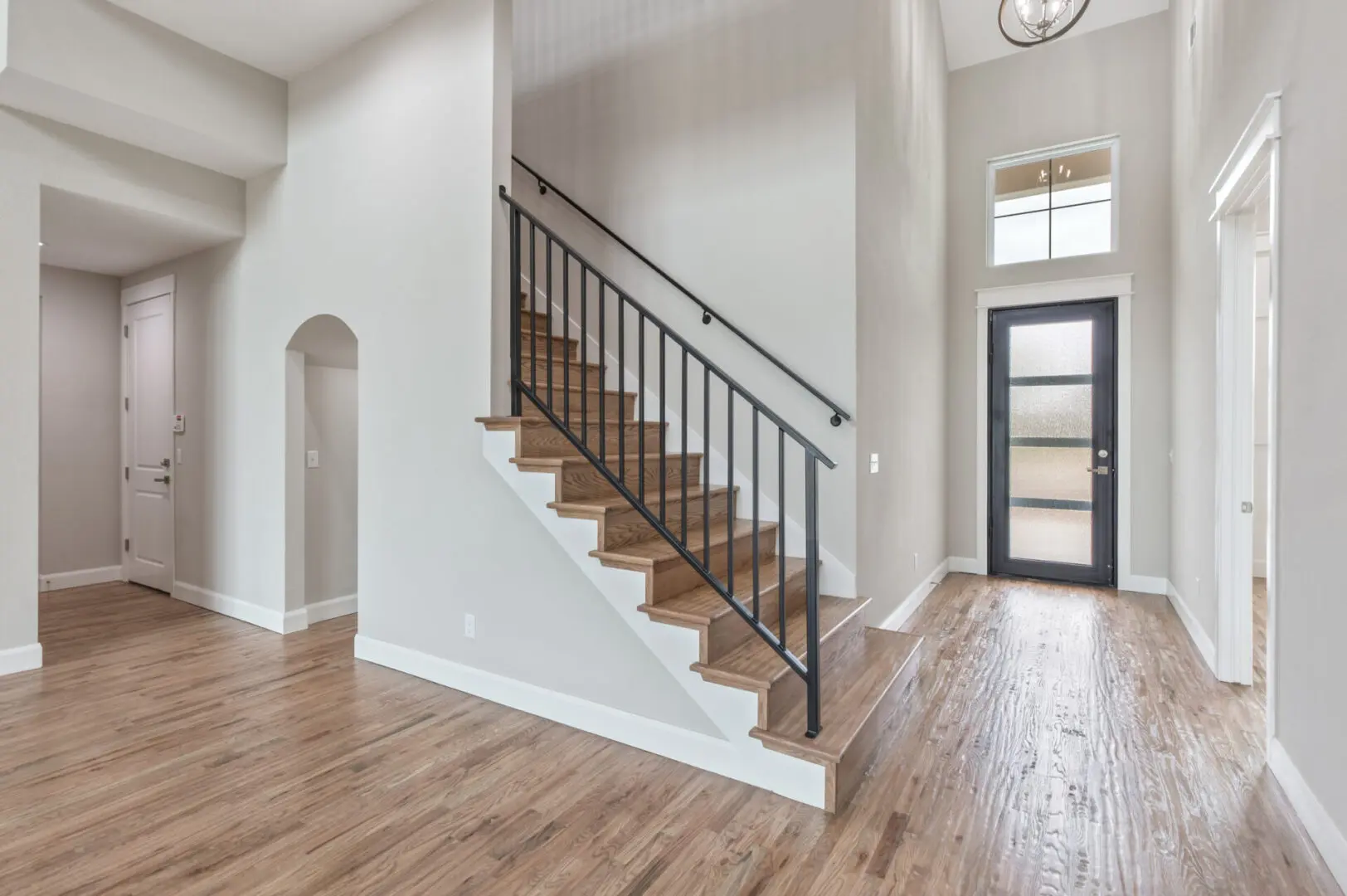 A large open floor plan with wood floors and white walls.