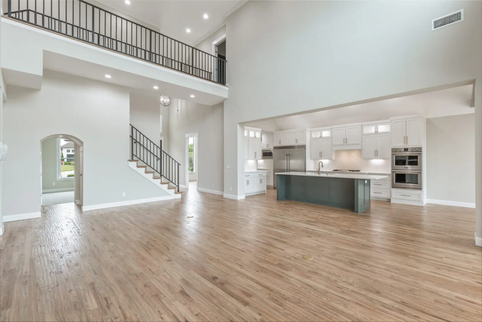 A large open floor plan with stairs and kitchen.