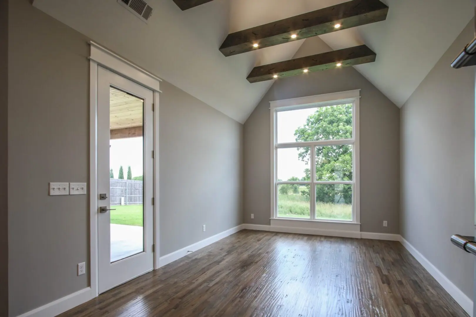 A room with wood floors and a large window.