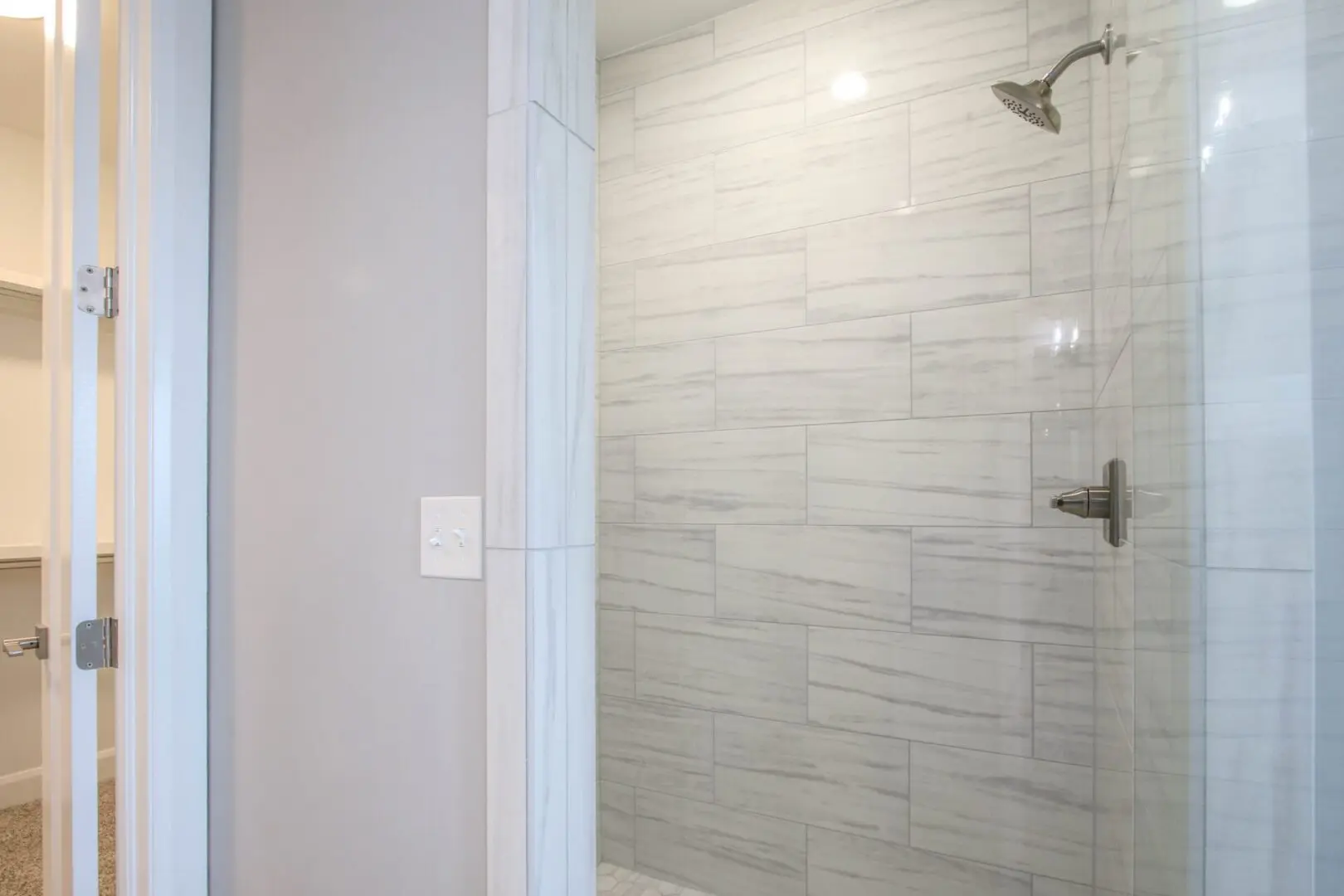 A bathroom with a shower and tiled walls.