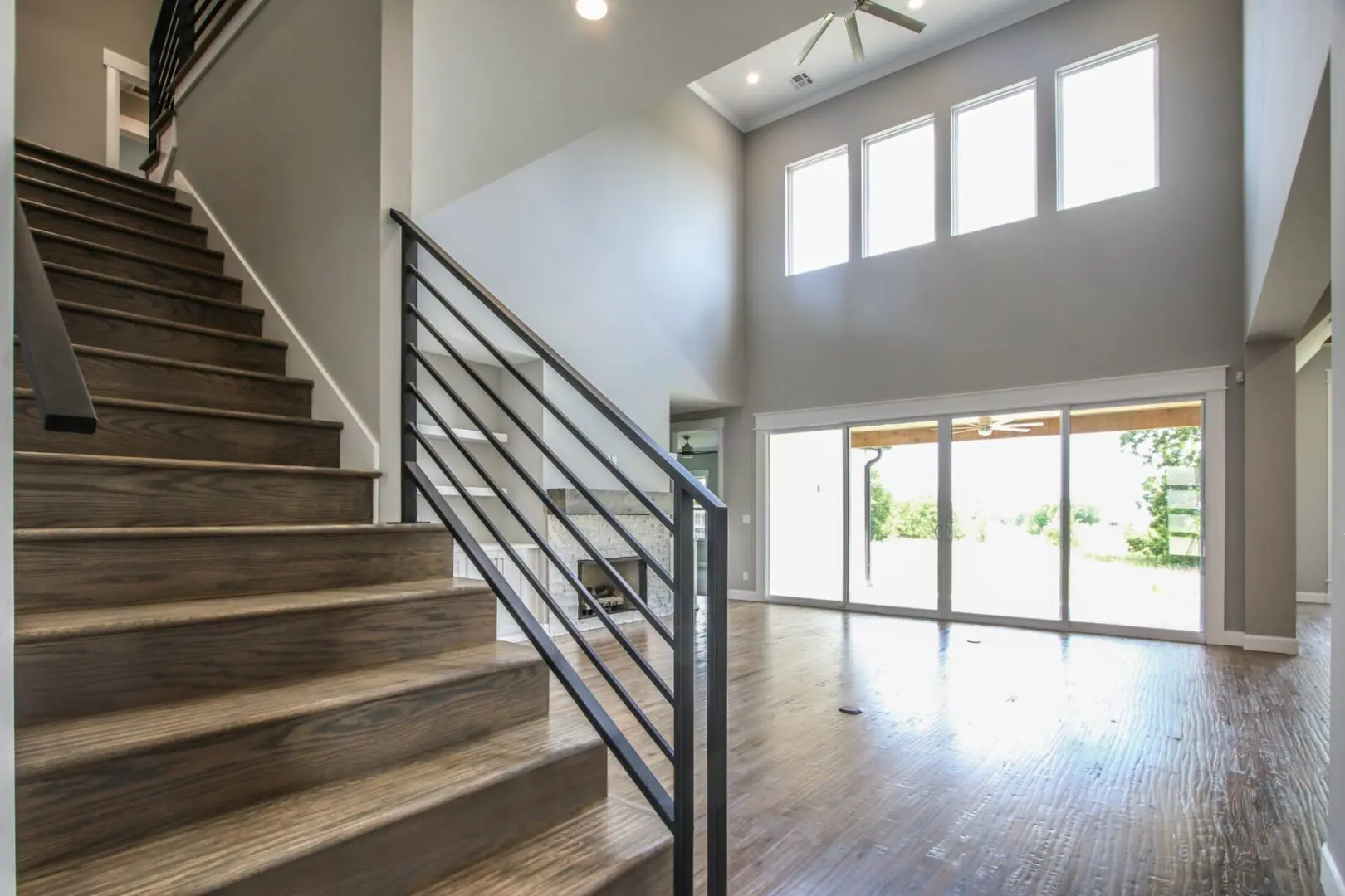 A large open room with stairs and sliding glass doors.