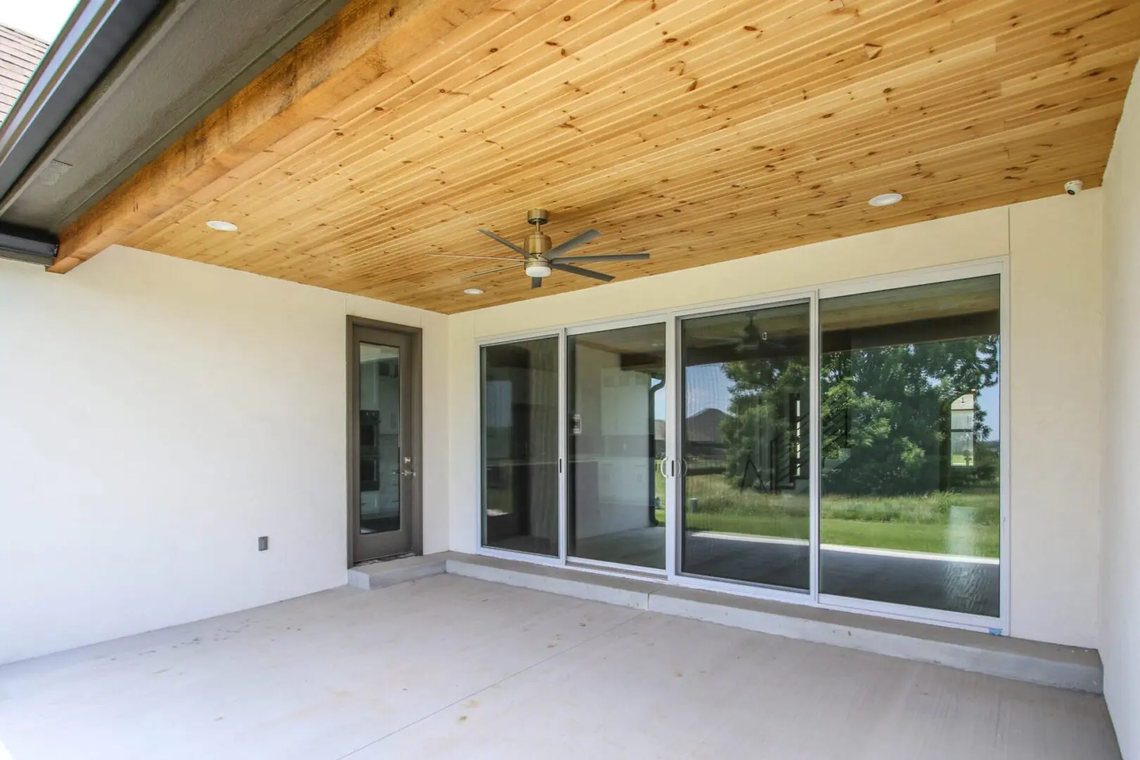 A large open porch with sliding glass doors.