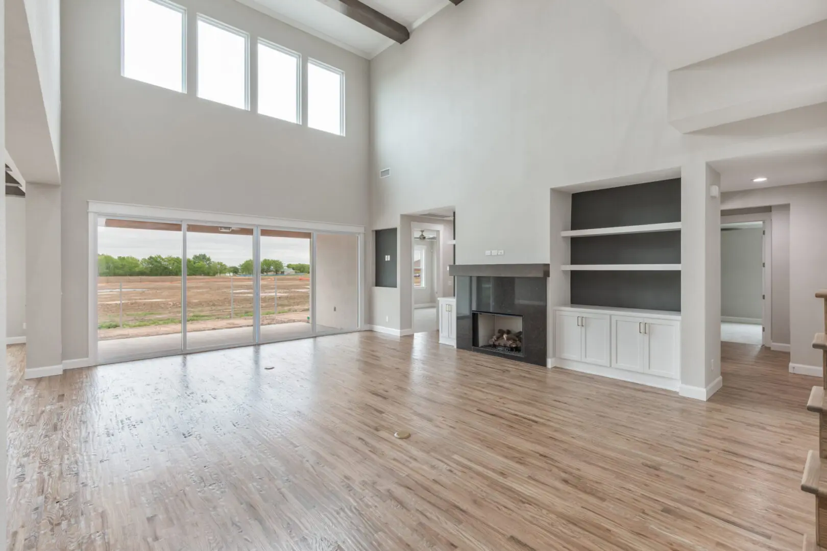 A large open living room with wood floors and white walls.