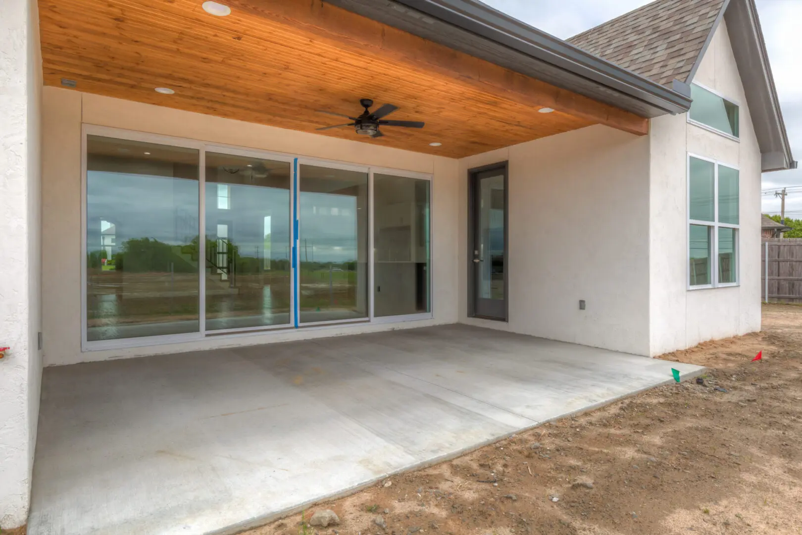 A patio with sliding glass doors and a ceiling fan.