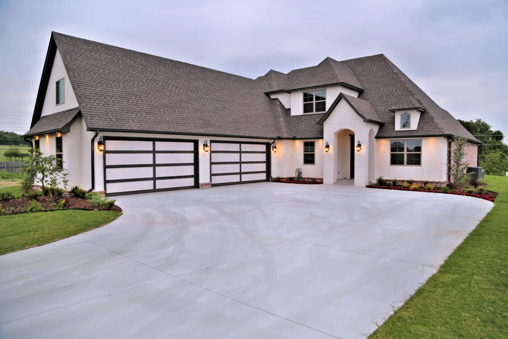 A large white house with two garage doors.