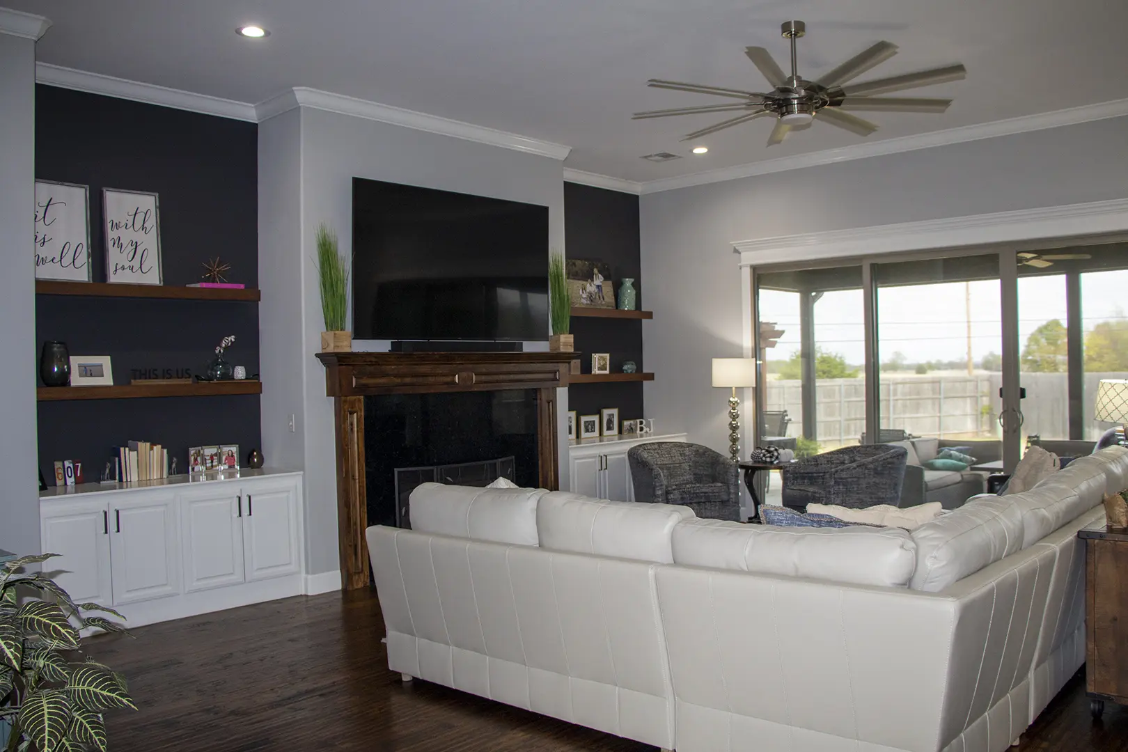 A living room with white furniture and a fireplace.