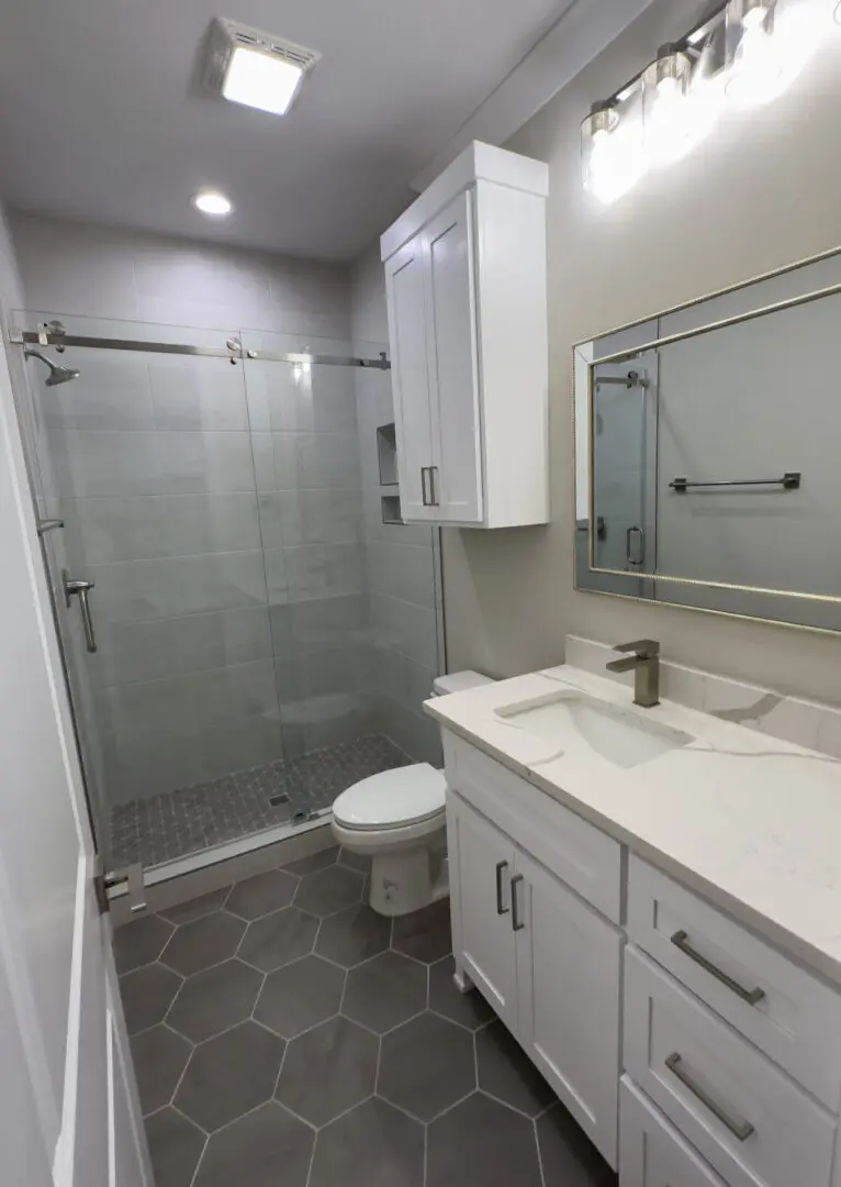 A bathroom with a toilet, sink and shower.