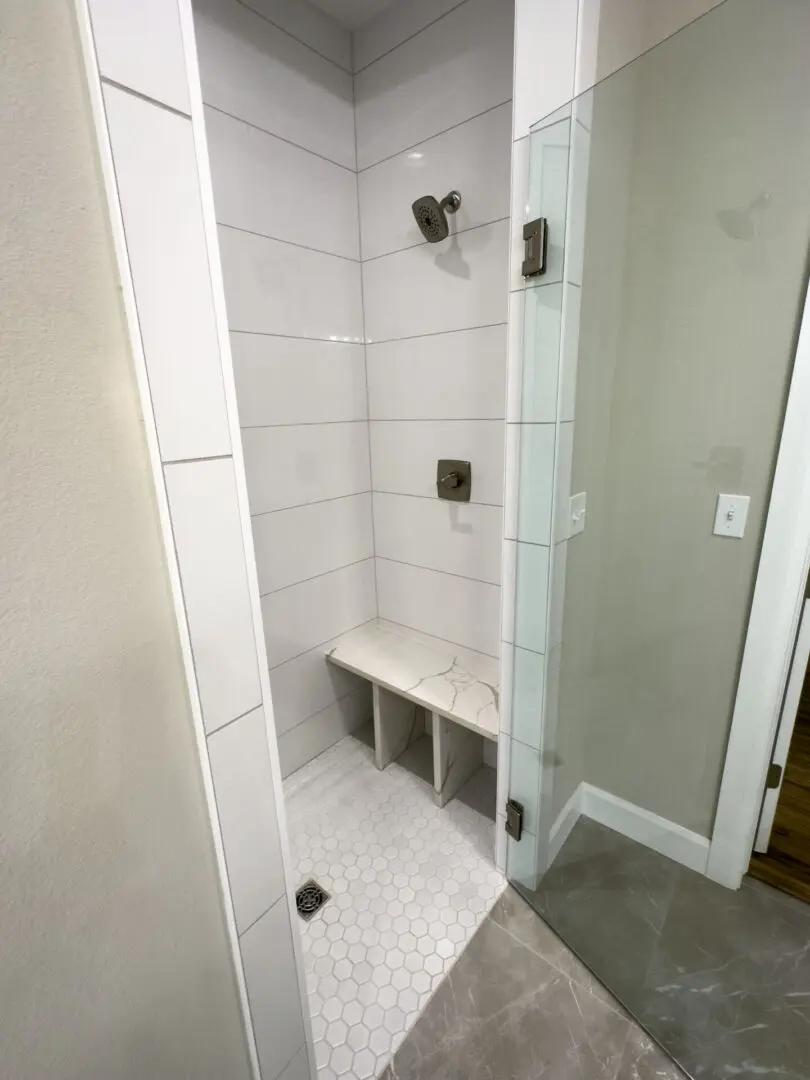 A bathroom with a bench and tiled walls.